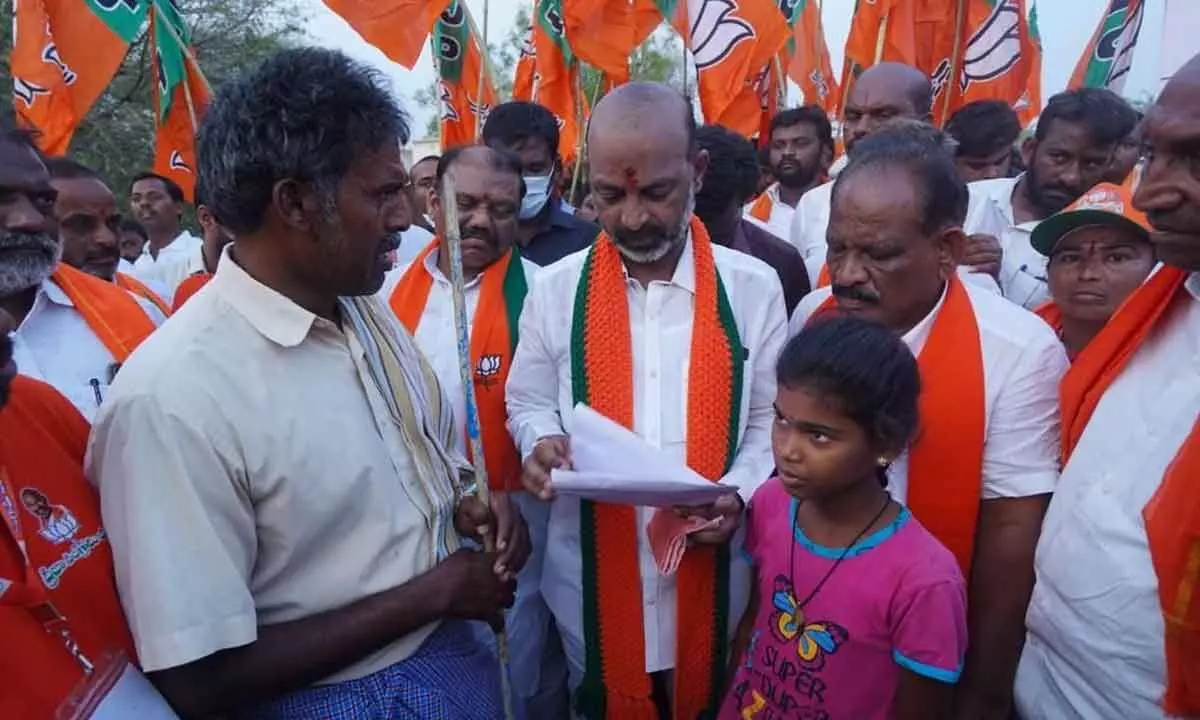 Bandi Sanjay Kumar interacting with poor daily wage workers at Shabad village on Monday