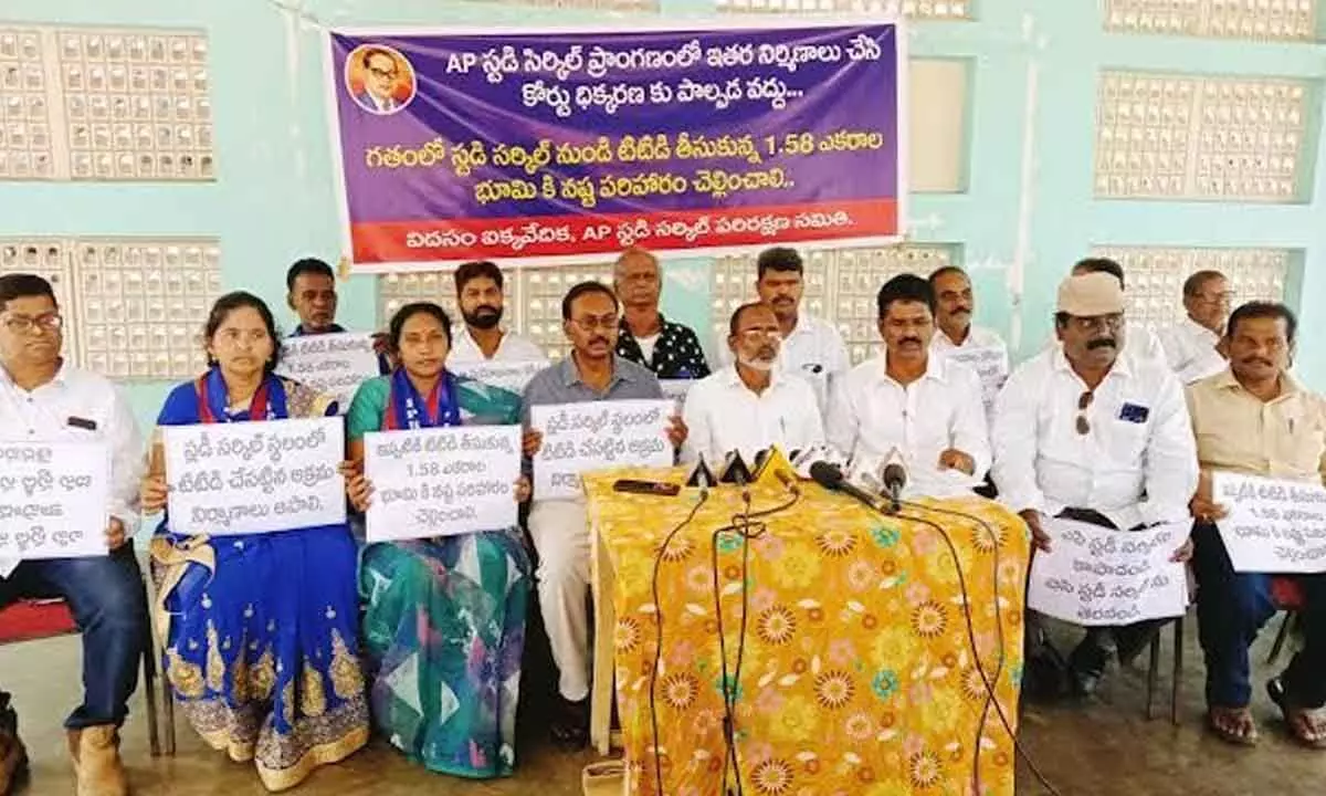 Members of AP Study Circle Parirakshana Samiti and Visakha District Dalit Unity Forum displaying placards to save site meant for the BC Welfare in Visakhapatnam on Wednesday