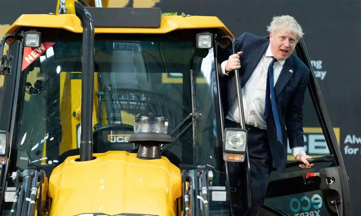 Britains Prime Minister Boris Johnson climbs onto a earthmover at the new JCB Factory in Vadodara on Thursday