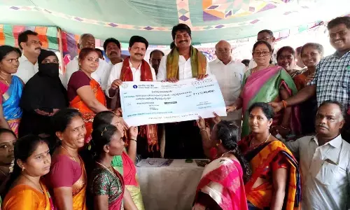 MP M Gurumoorthy and MLA Biyyapu Madhusudhan Reddy handing over the Sunna Vaddi scheme cheque to the SHG beneficiaries at a function in Srikalahasti on Saturday.