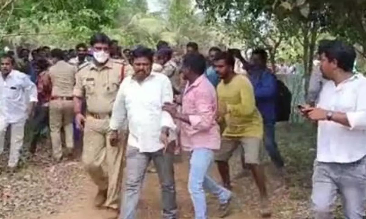 Gopalapuram MLA Talari Venkata Rao being taken into a school building for safety by police during an attack by his own party supporters on Saturday