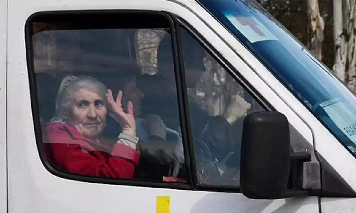 An elderly woman waves from a bus as civillians are evacuated. (File Photo | AP)