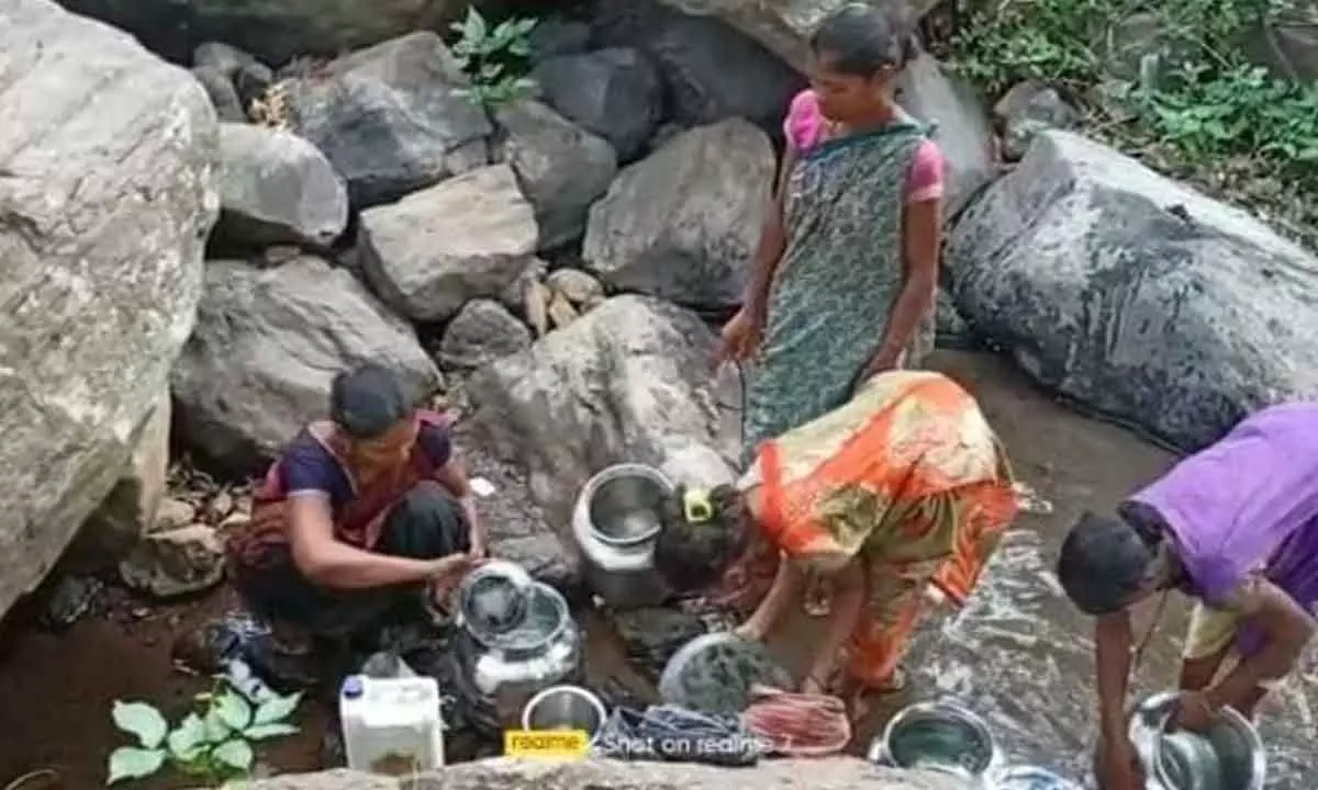 Tribal women fetching water from the gedda at Patha Losingi of Aarla panchayat in Rolugunta mandal