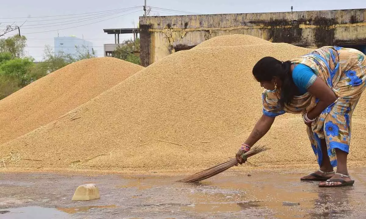 A woman is seen trying to sweep away rainwater in Jangaon district on Wednesday