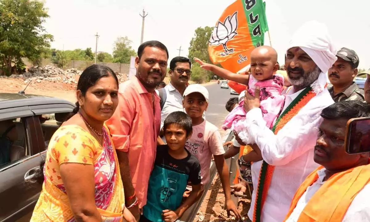 Bandi Sanjay poses for the camera with a family during the Praja Sangrama Yatra in Jadcherla on Saturday