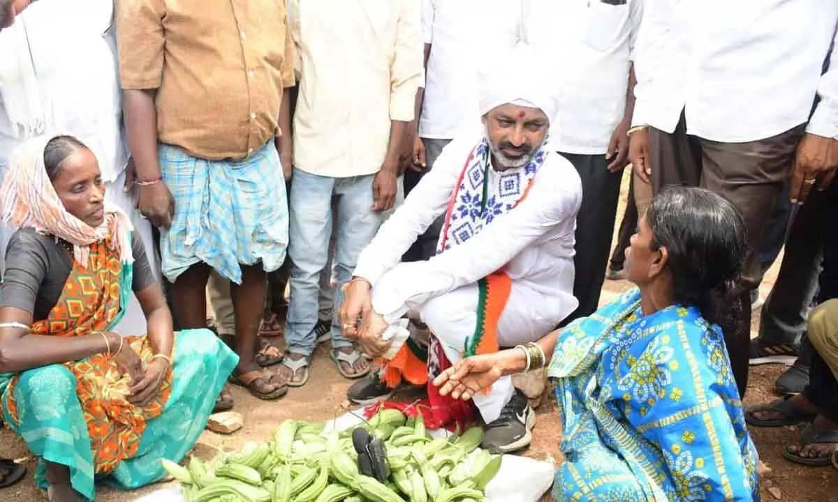 BJP State president Bandi Sanjay Kumar speaking to a women vegetable vendor in Kondedu village on Monday