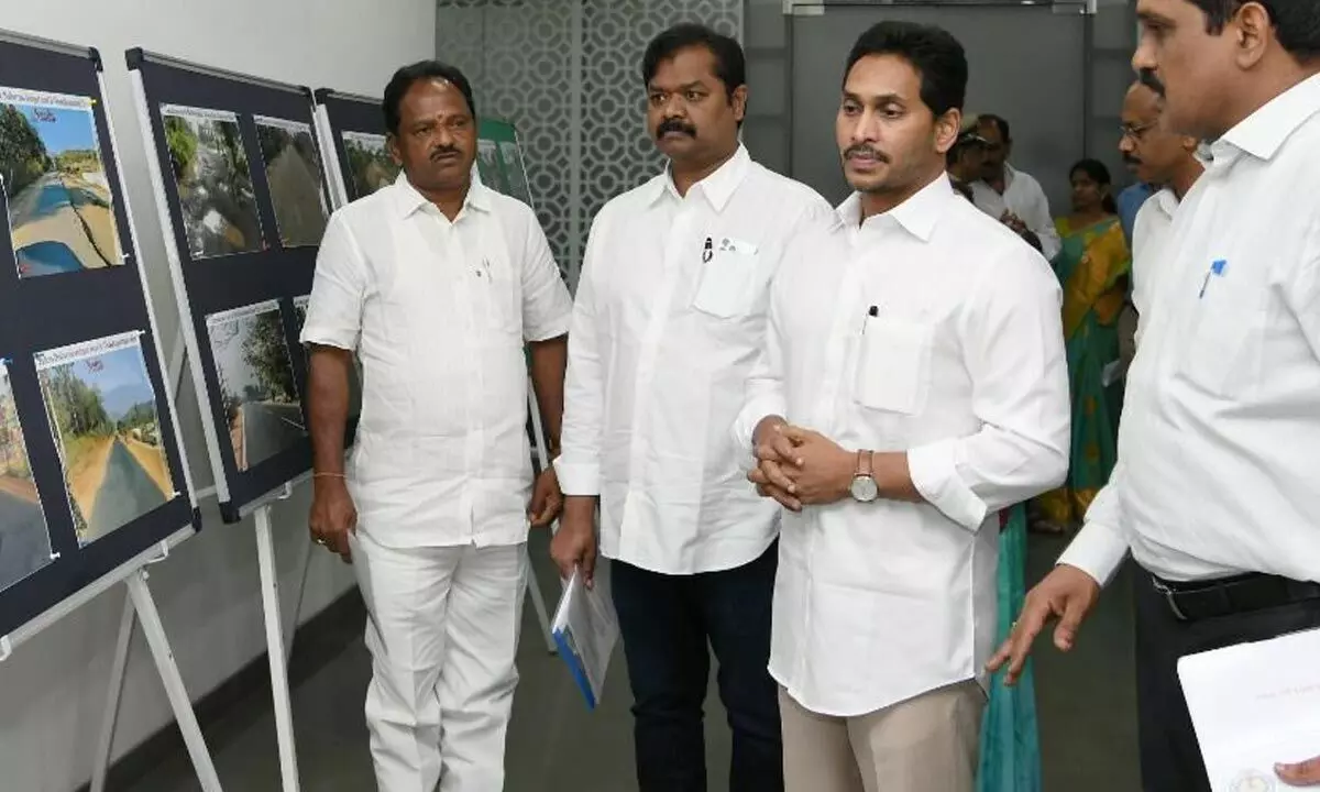 Chief Minister Y S Jagan Mohan Reddy looks at the photographs comparing the condition of roads during the previous TDP regime and now, at his camp office in Tadepalli on Wednesday