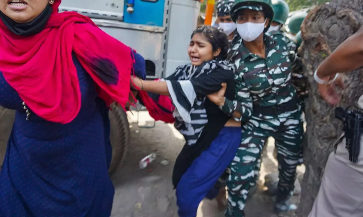 Security person attempt to disperse protestors during an anti-encroachment drive, in New Delhi on Thursday