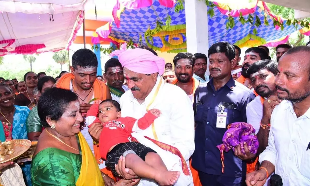 Minister for Panchayat Raj Errabelli Dayakar Rao cuddling a child during a programme at Raiparthy mandal headquarters in Warangal district on Saturday