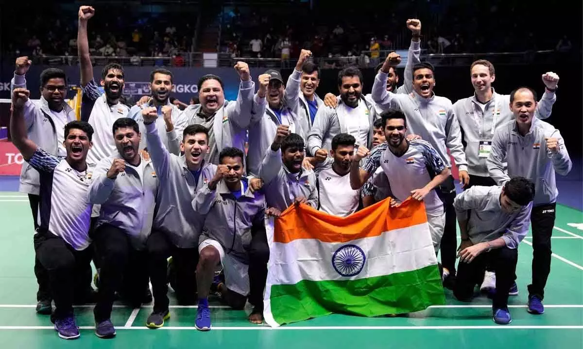Indias team members pose with their nation flag after winning Thomas Cup title in Bangkok, Thailand, on Sunday