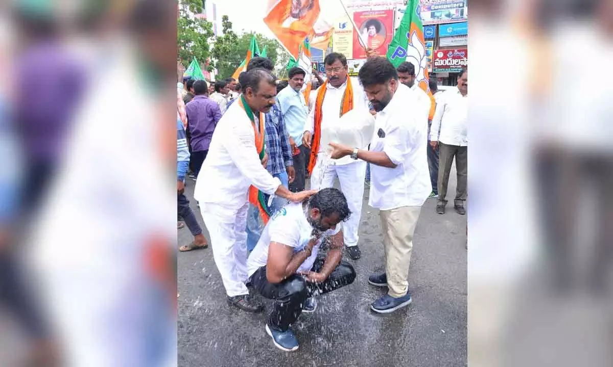 The BJP leaders  pouring water on Youth Morcha leader A Upender Gowd who doused himself  with petrol and tried to commit suicide in Khammam on Tuesday