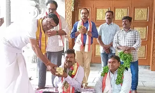 Temple official handing over Swamy Prasadam to State Health Director Dr Srinivas Rao during his visit to Yadadri on Tuesday
