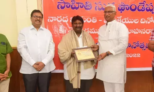 The Hans India photographer Ch Venkata Mastan receiving the best photojournalist award at a programme at Siddhartha Degree College mini stadium in Vijayawada on Wednesday