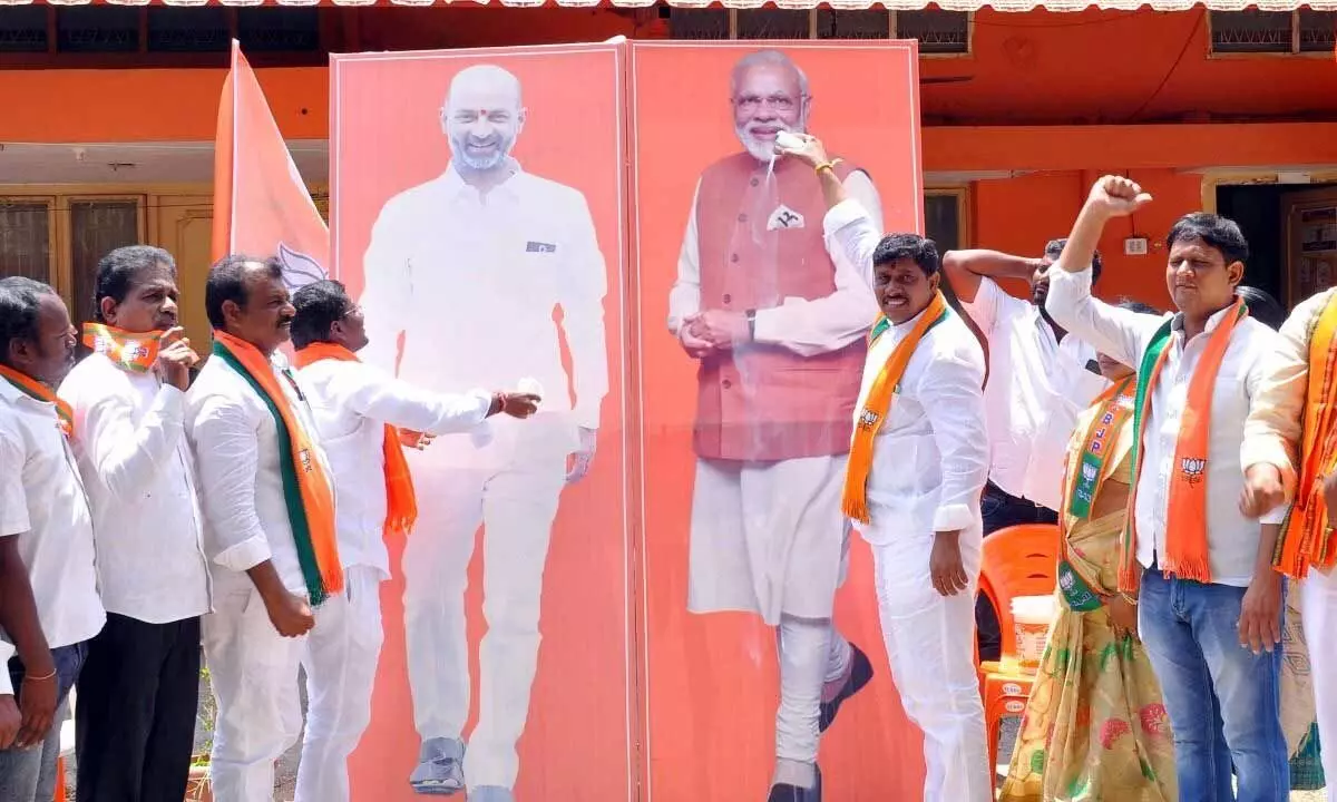 BJP leaders performing palabhishekam to the portraits of PM Narendra Modi and state party chief  Bandi Sanjay Kumar at the district party office in Khammam on Sunday.