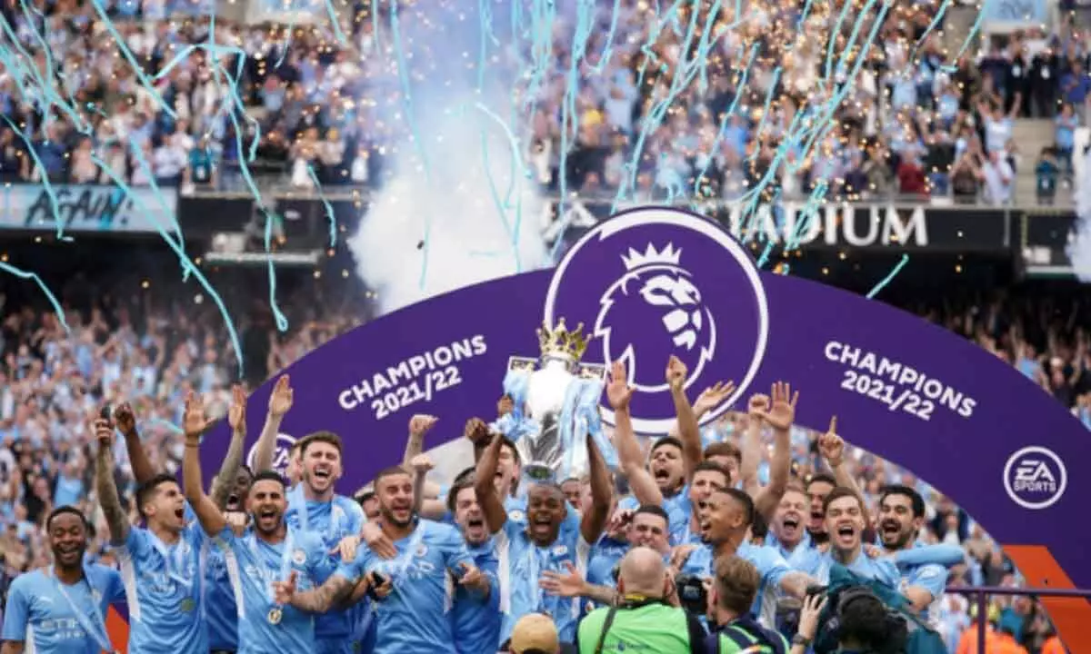 Manchester Citys Fernandinho (center) lifts the English Premier League trophy as he celebrates with teammates  at The Etihad Stadium, Manchester, England, late on Sunday. At right is Citys Ilkay Gundogan