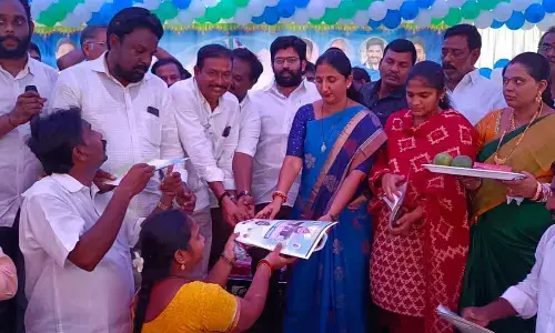 District Collector Dr K Madhavi Latha and MLA Jakkampudi Raja distributing title deeds to beneficiaries at Thokada village on Tuesday