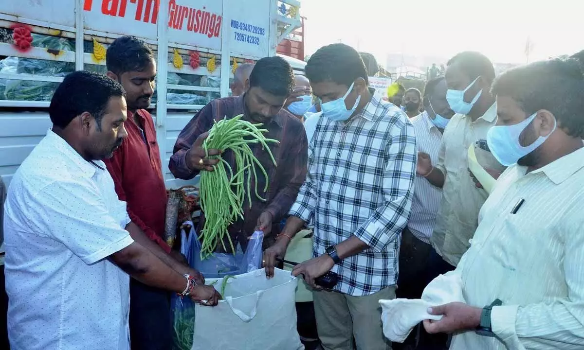 GVMC Commissioner G Lakshmisha encouraging consumers to use cloth bags at Gnanapuram wholesale vegetable market in Visakhapatnam on Saturday