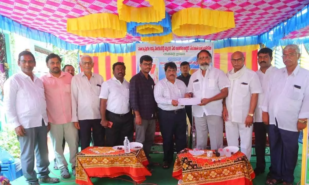 Markapuram Ram Bhupal Reddy presenting the cheque of the deposit to the postal department officials through the hands of Giddalur MLA Anna Rambabu at a programme in Yadavalli village on April 30
