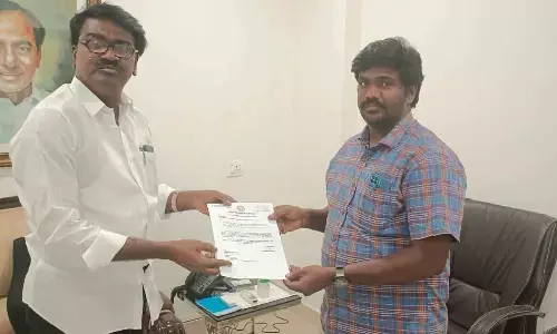 Minister Puvvada handing over a CMRF cheque of Rs 5 lakh for the treatment of an ailing delivery boy at his camp office in Hyderabad on Monday