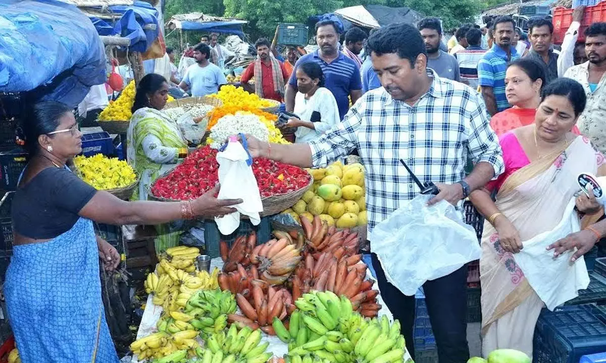 Municipal Commissioner encouraging a fruit vendor to use cloth bags instead of plastic during his recent field visit to Anakapalle