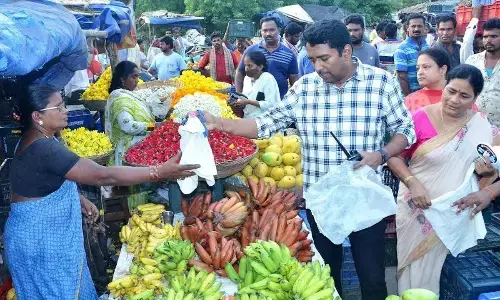 Municipal Commissioner encouraging a fruit vendor to use cloth bags instead of plastic during his recent field visit to Anakapalle