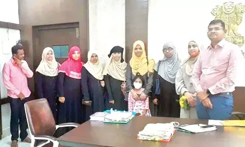 VMC Commissioner Swapnil Dinkar Pundkar congratulating SNMC High School staff and students for securing 100% results in SSC public examinations, at his chambers in Vijayawada on Tuesday