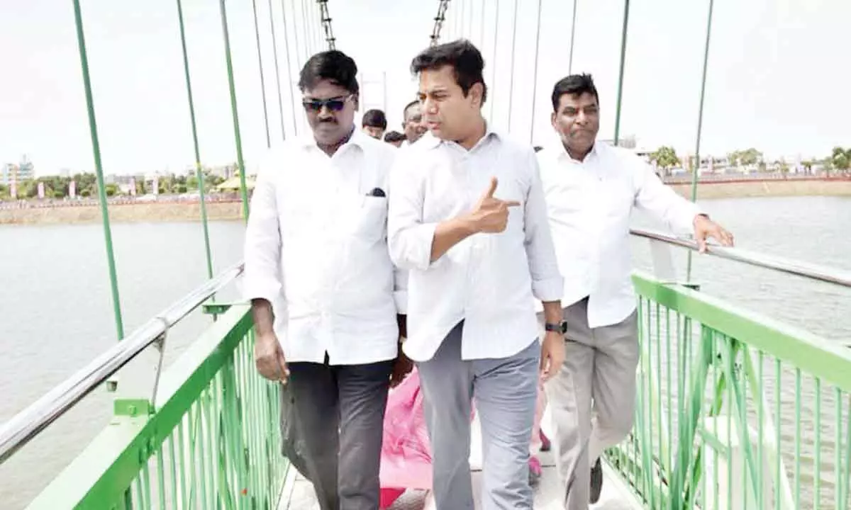 Ministers KTR and Ajay walking on suspension bridge at Lakaram tank bund after the inauguration in Khammam on Saturday
