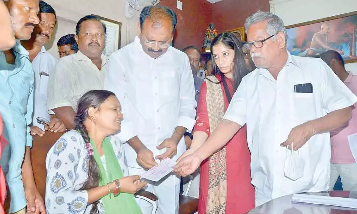 MCT workers union leader Thulasendra along with MLA Bhumana Karunakar Reddy handing over a cheque for Rs 5 lakh to MCT sanitary worker Armugams wife, at the Municipal Office on Thursday.