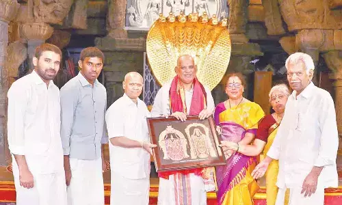TTD EO AV Dharma Reddy presenting Lords laminated photo to TUDA chief Chevireddy Bhaskar Reddy after he takes oath as TTD Trust Board ex-officio member in Tirumala temple on Thursday.