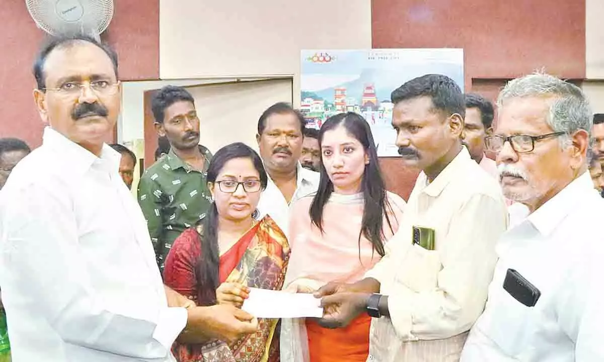 MLA Bhumana Kaurnakar Reddy along with Mayor Sirisha and Commissioner Anupama Anjali handing over a cheque of Rs 5 lakh to Maheshs family member at Municipal Office in Tirupati on Friday