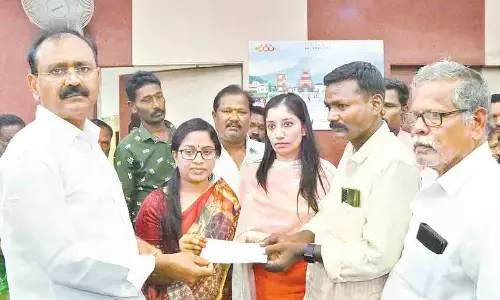 MLA Bhumana Kaurnakar Reddy along with Mayor Sirisha and Commissioner Anupama Anjali handing over a cheque of Rs 5 lakh to Maheshs family member at Municipal Office in Tirupati on Friday