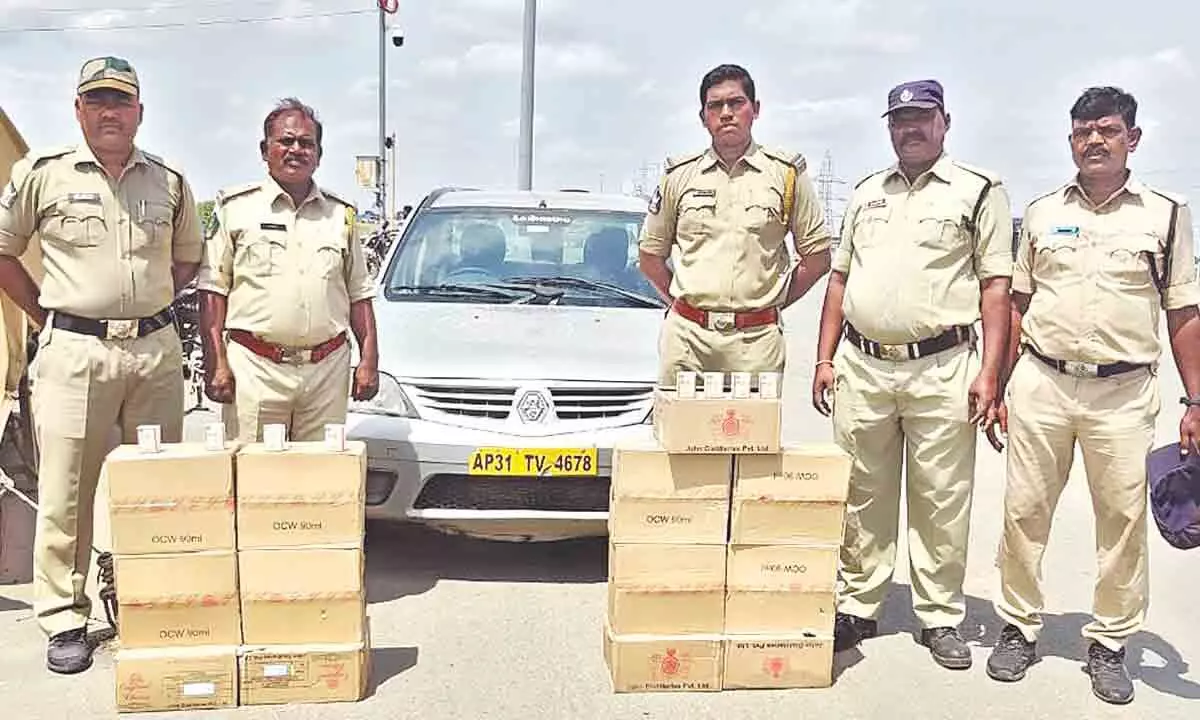 SEB Sub-inspector Praveen Naik and his staff with seized liquor at Panchalingla border check post on Saturday.