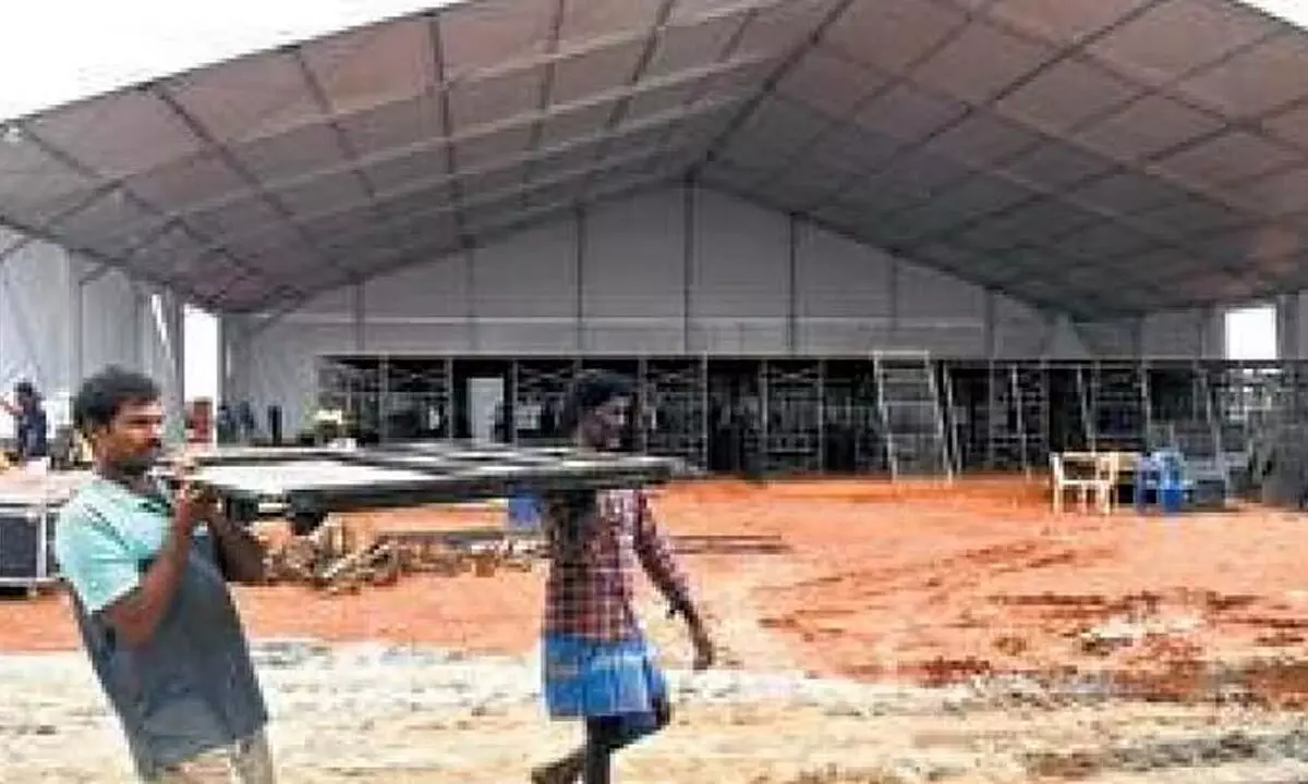 Workers erect a stage at Kommaghatta