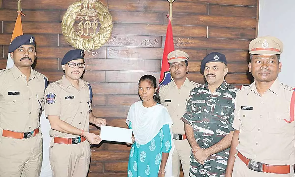 SP Sunil Dutt handing over Rs 4 lakh assistance  to the surrendered woman Maoist in Kothagudem on Tuesday