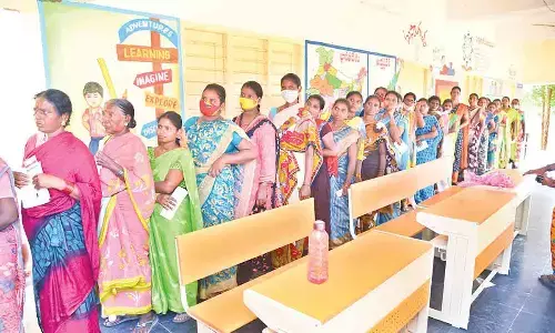 Women stand in queue lines at Gandhi Girijana Sangam polling centre in Sangam mandal on Thursday