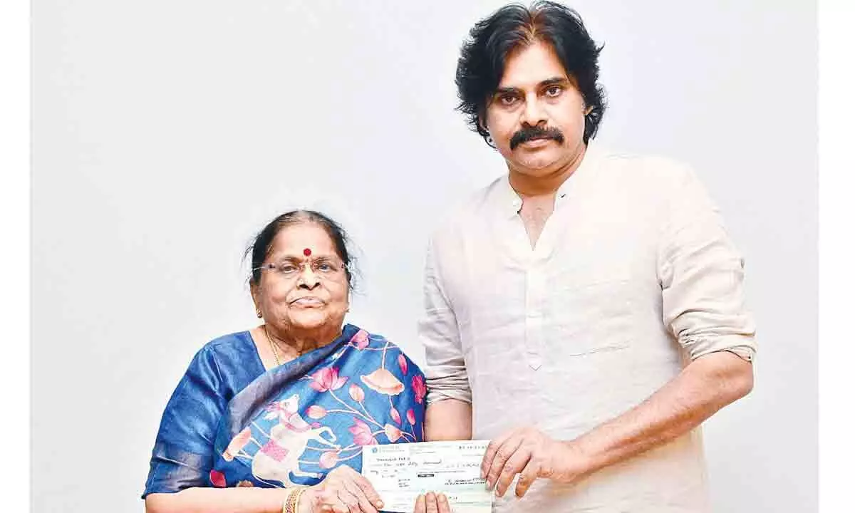 K Anjana Devi handing over a cheque towards donation to JSP to party president and her son Pawan Kalyan