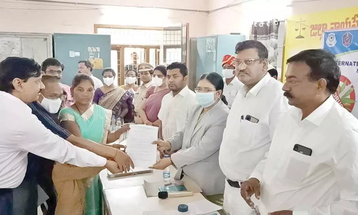 District Principal Judge PV Jyothirmai presenting the award (decree) to the clients in a case that was settled amicably in the Lok Adalat held in the District Court in Rajahmundry on Sunday