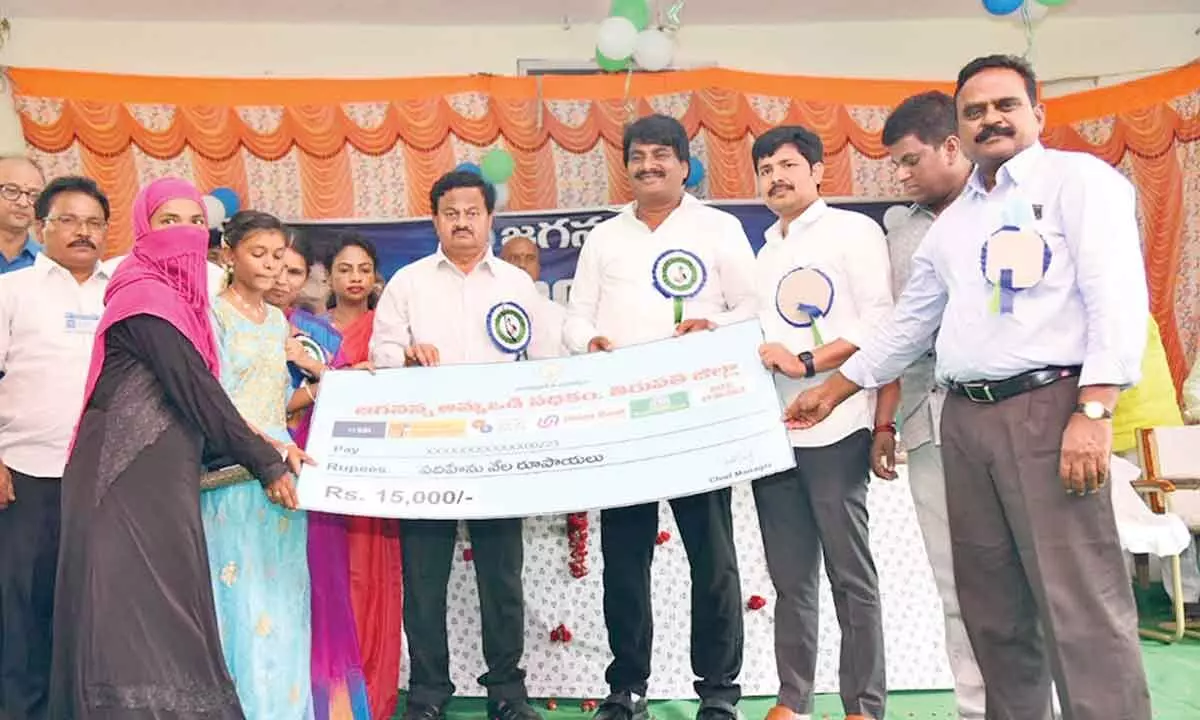 District Collector K Venkata Ramana Reddy, MLA Madhusudan Reddy, MP M Gurumoorthy and others handing over replica of Amma Vodi cheque to a beneficiary in Srikalahasti on Monday