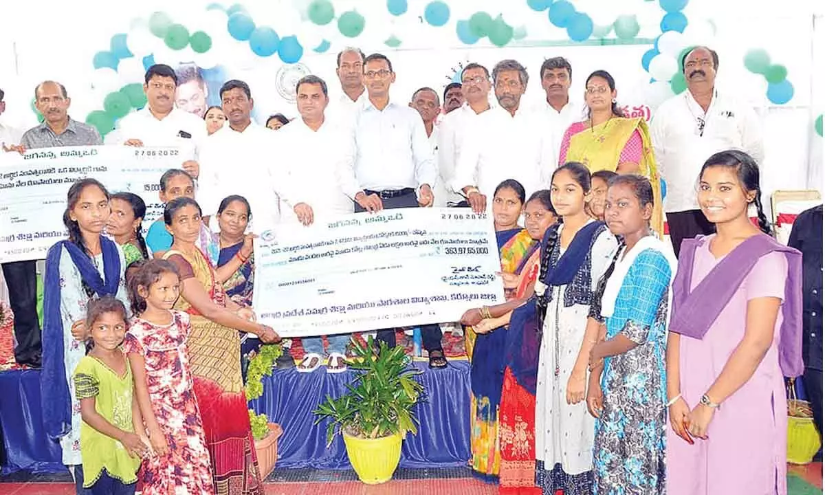 District Collector P Koteshwara Rao along with the MLAs of Panyam, Kodumur and Deputy Mayor presenting a replica of mega cheque Rs 363.97 crore to the parents of children at the Collectorate in Kurnool on Monday.