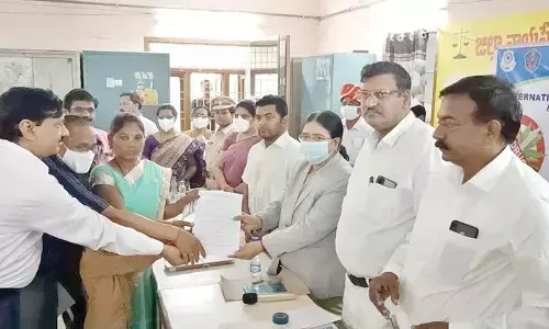 District Principal Judge PV Jyothirmai presenting the award (decree) to the clients in a case that was settled amicably in the Lok Adalat held in the District Court in Rajahmundry on Sunday