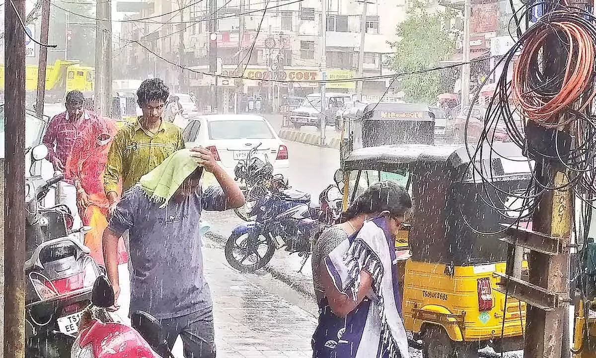 Passers-by scurry for the cover near Paradise circle as sudden rain lashed twin cities on Tuesday evening.  	Photo: Ch Prabhu Das