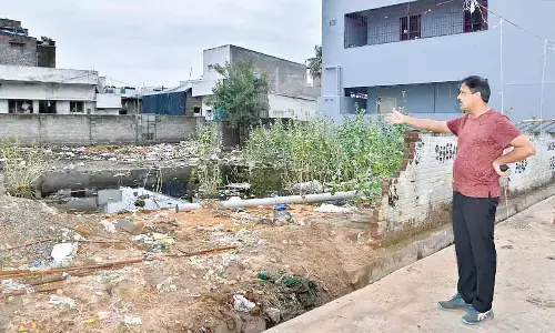 Kakinada Municipal Corporation Commissioner K Ramesh inspecting an open site at Gollapeta in Kakinada on Tuesday
