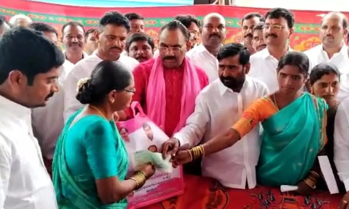 Minister Jagadsih Reddy distributing Kalyana Laxmi cheques to beneficiaries during his tour in Munugodu constituency on Wednesday