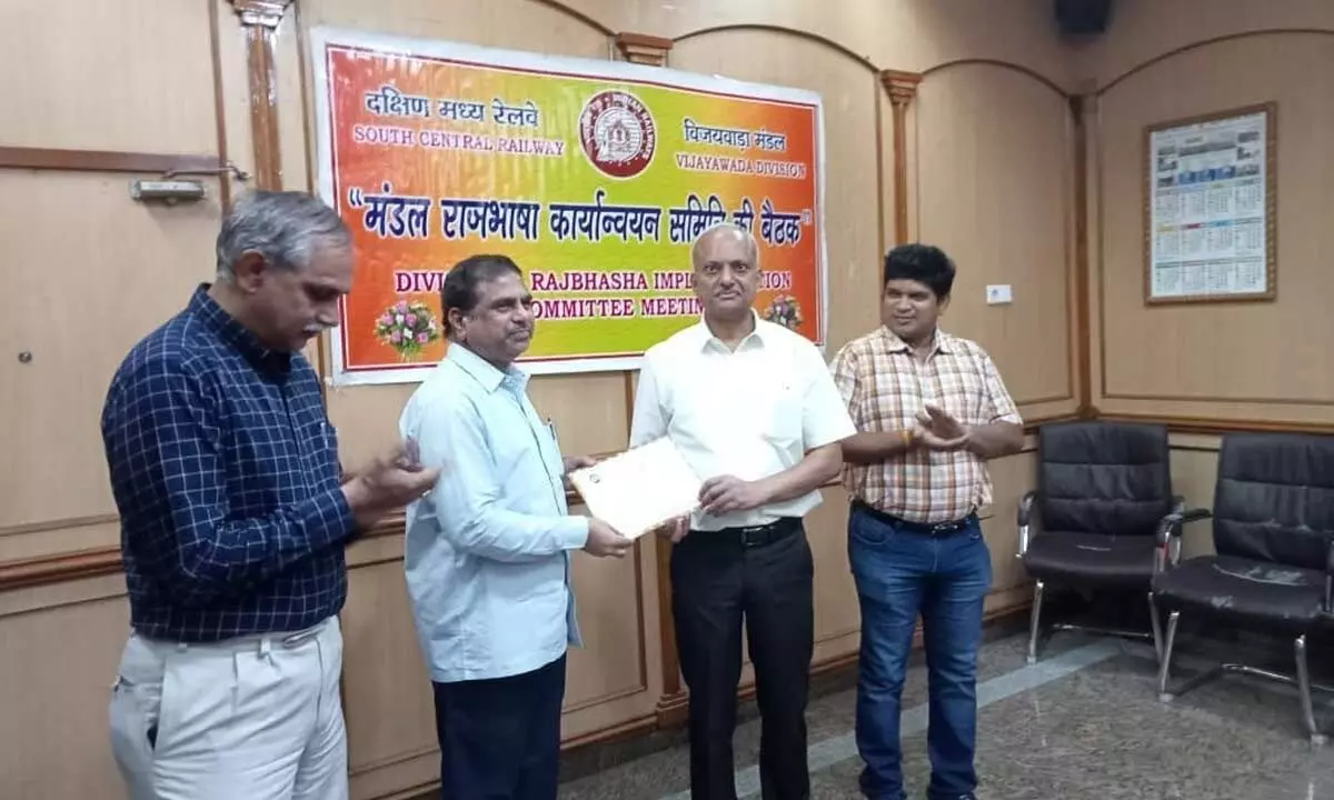 Divisional Railway Manager Shivendra Mohan presenting certificates to an employee, who have done excellent work in Hindi during the year, at a meeting in Vijayawada on Wednesday