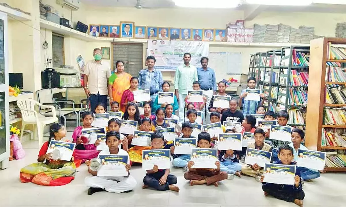 Students, who received merit certificates and gifts, along with retired manager of IOB KBG Tilak, Librarian Aleti Prabha, T Prasad Babu, Dosapati Nageswara Rao and T Vinod on Thursday at the valedictory function of Summer Knowledge Camp at Grade-1 branch library at Jaggaiahpet on Thursday