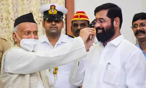 Maharashtra Governor Bhagat Singh Koshyari offers sweets to rebel Shiv Sena leader Eknath Shinde, in Mumbai on Thursday