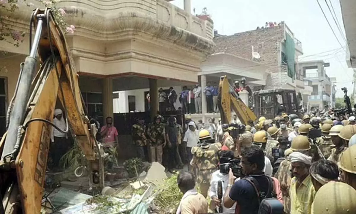 A bulldozer being used to demolish the residence of Javed Mohammad in Prayagraj. (Photo | PTI)