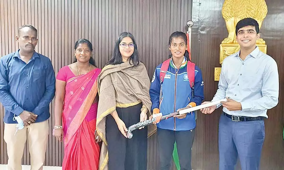 District Collector Pattanshetti Ravi Subash presenting a hockey stick to player Bhavani in Anakapalli district on Saturday