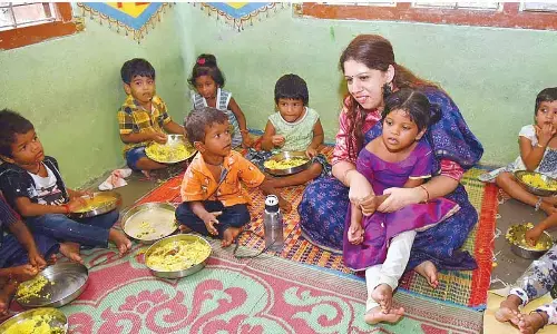 Collector Krithika Shukla with the kids at the Anganwadi Centre at Vakalapudi in Kakinada on Saturday