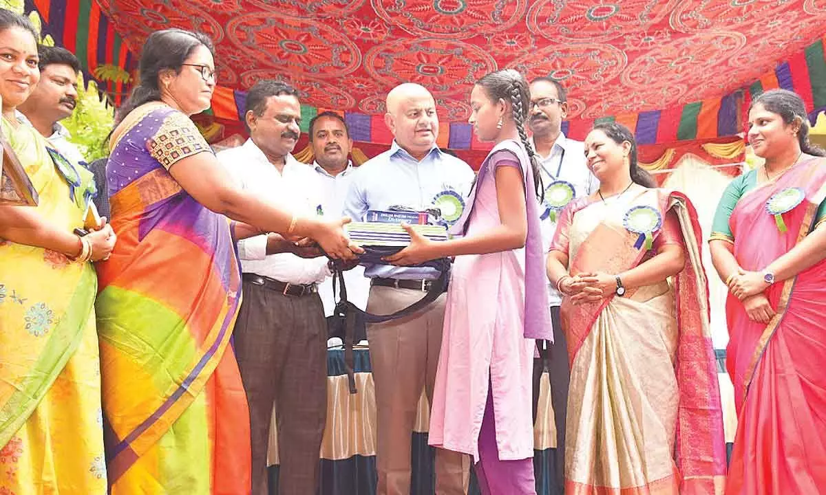 District Collector K Venkata Ramana Reddy distributing Jagananna Vidya Kanuka kit to a student at Padmavathipuram ZP High School in Tirupati on Tuesday. DEO Dr V Sekhar, sarpanch Jyothi and others are also seen.